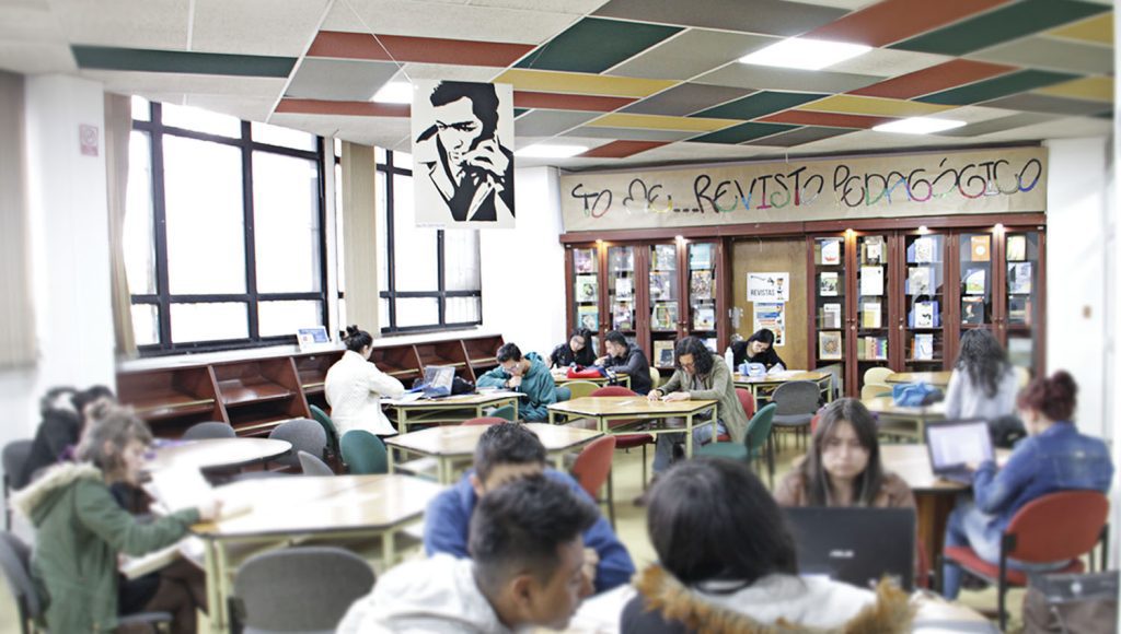 Fotografía de sala hemeroteca con varios estudiantes leyendo revistas.